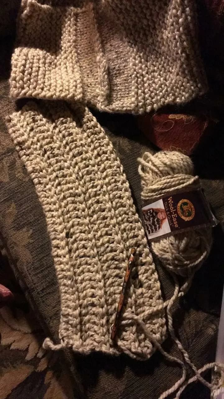 Beige knit scarf with yarn and crochet hook