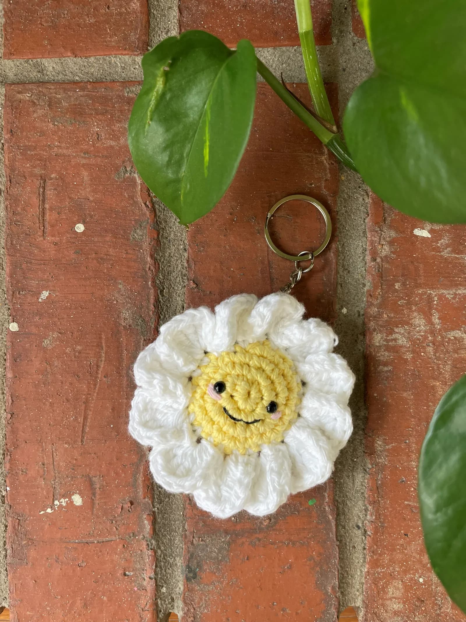 White and yellow smiling daisy crochet keychain