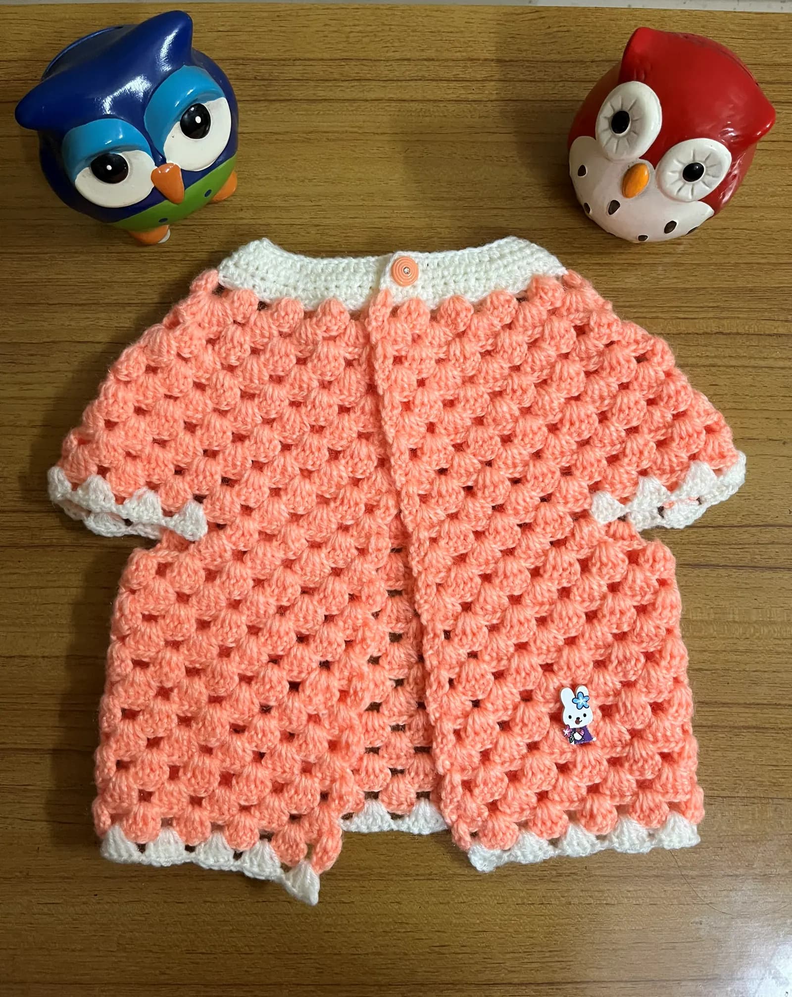 Peach crochet baby cardigan with textured stitch